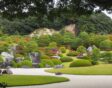 Een pad door een Japanse tuin bij het Adacht Museum of Art, met veel strak gesnoeide planten.