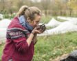 Esther houdt handen vol bokashicompost dichtbij haar gezicht om de geur te ruiken.